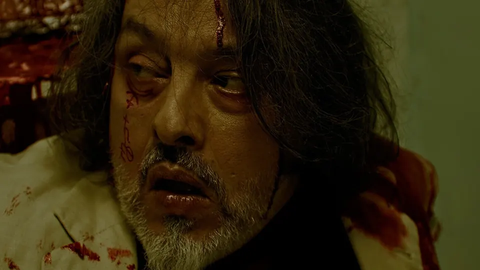 Grim close-up of a bloodied older man