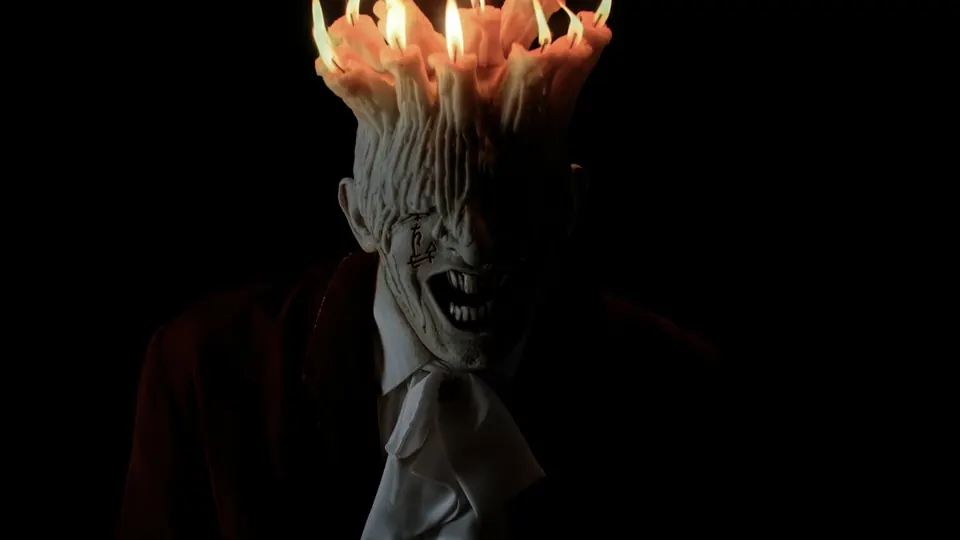 Candle-headed monster emerging from darkness