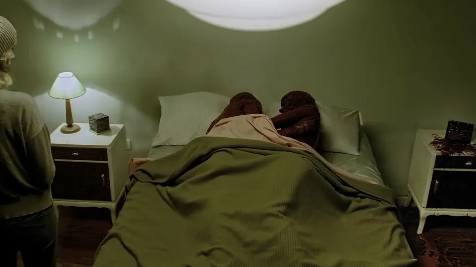 Character resting in bed in a dim green room